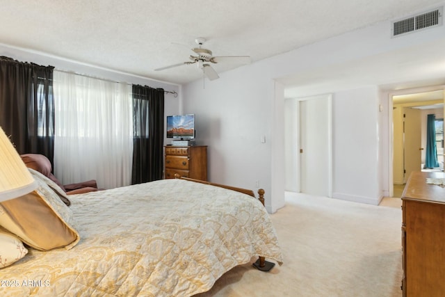 carpeted bedroom with multiple windows, ceiling fan, and a textured ceiling