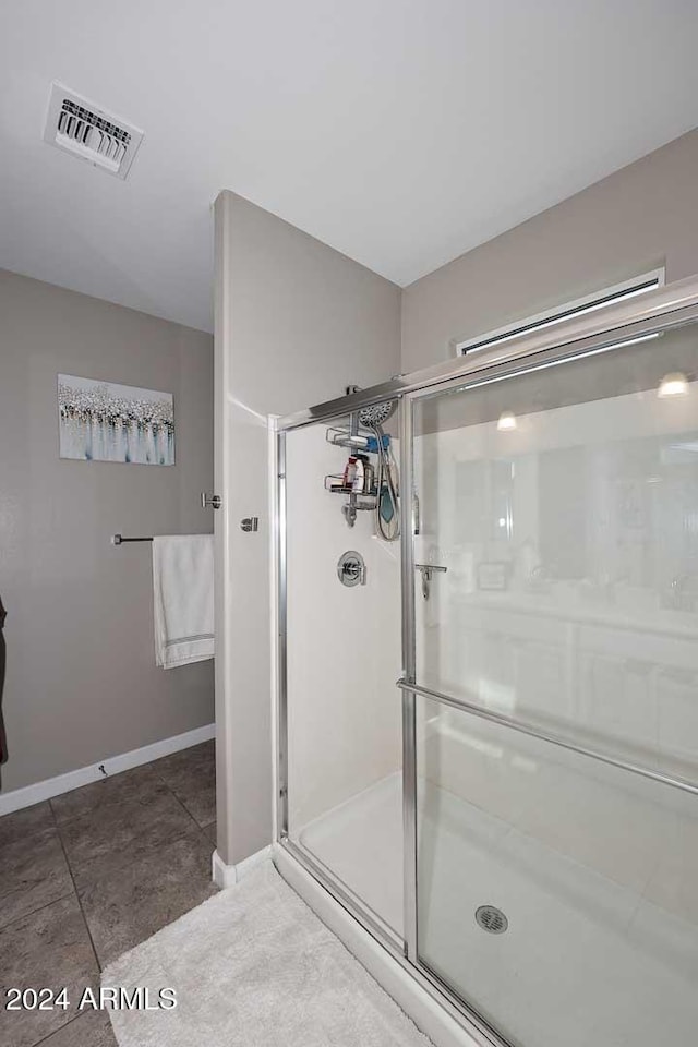 bathroom featuring a shower with door and tile patterned flooring