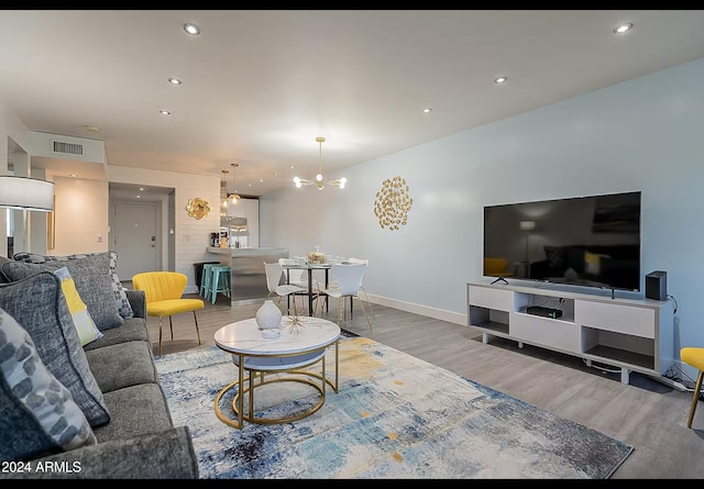 living room featuring a chandelier and wood-type flooring