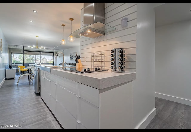 kitchen with black electric stovetop, hanging light fixtures, island range hood, dark hardwood / wood-style flooring, and white cabinetry