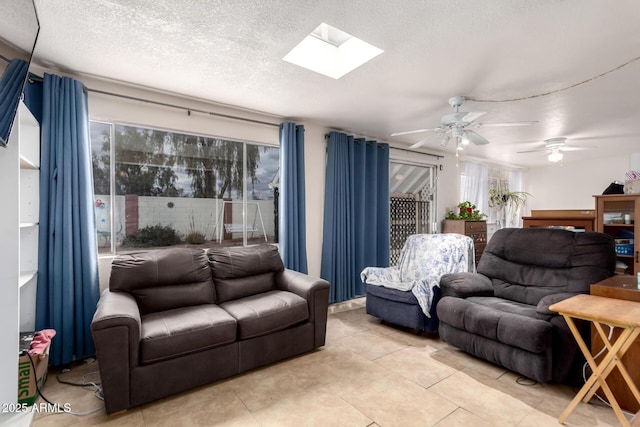 living room with light tile patterned flooring, a textured ceiling, and a skylight