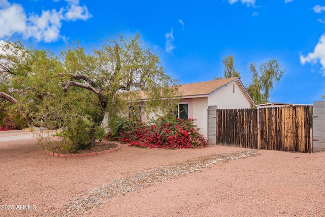 view of property exterior featuring stucco siding and fence