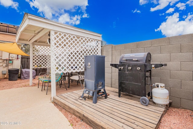 wooden terrace with grilling area, outdoor dining area, and fence