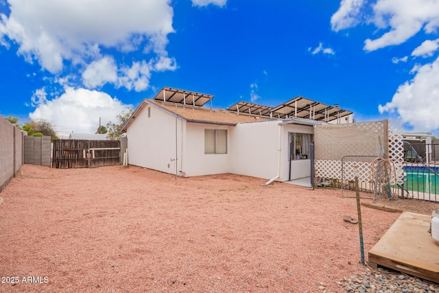 back of property with stucco siding and a fenced backyard