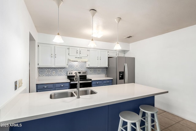 kitchen with a breakfast bar, under cabinet range hood, a sink, tasteful backsplash, and appliances with stainless steel finishes