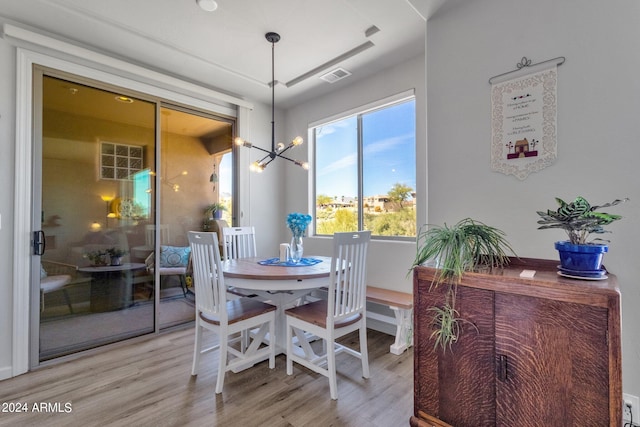 dining space with a notable chandelier, light hardwood / wood-style floors, and a wealth of natural light