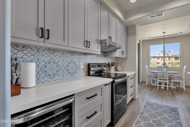 kitchen with wall chimney exhaust hood, beverage cooler, light hardwood / wood-style flooring, tasteful backsplash, and electric range