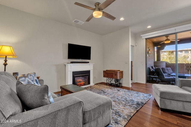 living room with dark hardwood / wood-style flooring and ceiling fan