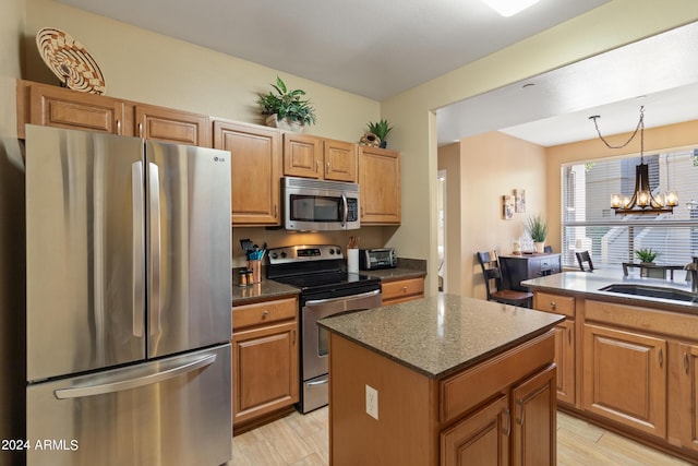 9550 E Thunderbird Rd Unit 152, Scottsdale, AZ 85260 - kitchen featuring appliances with stainless steel finishes, a chandelier, a center island, and light wood-type flooring
