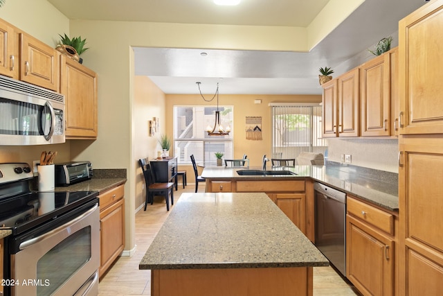 9550 E Thunderbird Rd Unit 152, Scottsdale, AZ 85260 - kitchen with stainless steel appliances, a peninsula, a chandelier, a kitchen island, and dark stone countertops