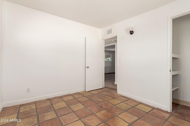 spare room with a textured ceiling