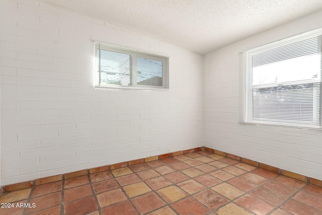 spare room featuring a healthy amount of sunlight and a textured ceiling