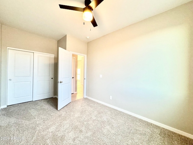 unfurnished bedroom with light carpet, a closet, and ceiling fan