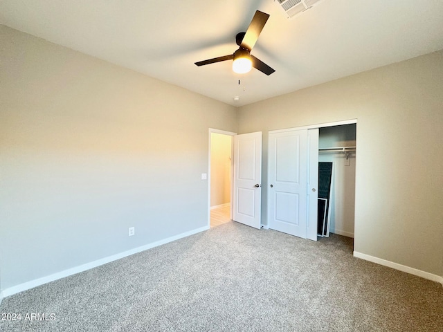 unfurnished bedroom with light carpet, a closet, and ceiling fan