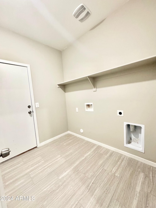 clothes washing area with gas dryer hookup, light hardwood / wood-style flooring, hookup for a washing machine, and electric dryer hookup