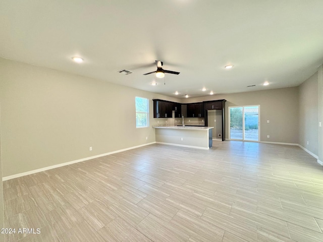 unfurnished living room with sink and ceiling fan