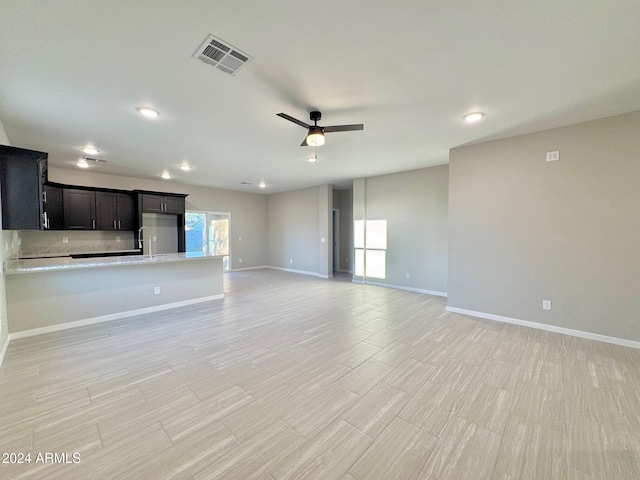 unfurnished living room with ceiling fan and light hardwood / wood-style flooring