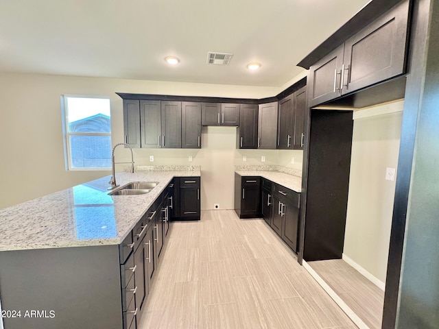 kitchen with light stone counters and sink