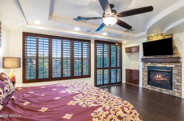 921 E Canyon Way, Chandler, AZ 85249 - bedroom featuring a tray ceiling, a fireplace, dark wood-style floors, and recessed lighting