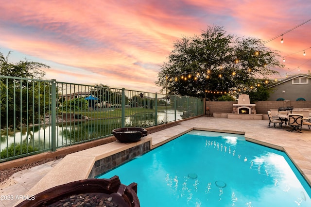 921 E Canyon Way, Chandler, AZ 85249 - view of swimming pool with a warm lit fireplace, a patio, and a fenced backyard