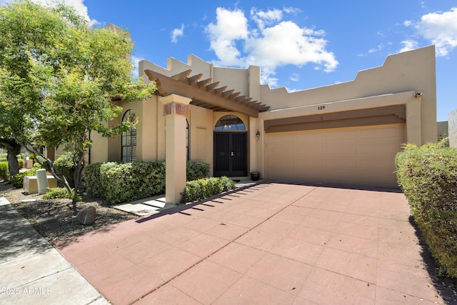 7955 E Chaparral Rd Unit 129, Scottsdale, AZ 85250 - pueblo revival-style home featuring driveway, a garage, and stucco siding