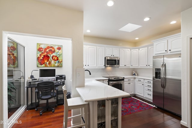 7955 E Chaparral Rd Unit 129, Scottsdale, AZ 85250 - kitchen featuring stainless steel appliances, dark wood finished floors, white cabinets, a peninsula, and recessed lighting