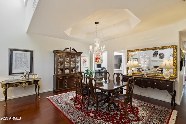 7955 E Chaparral Rd Unit 129, Scottsdale, AZ 85250 - dining area featuring a chandelier, a raised ceiling, and dark wood finished floors