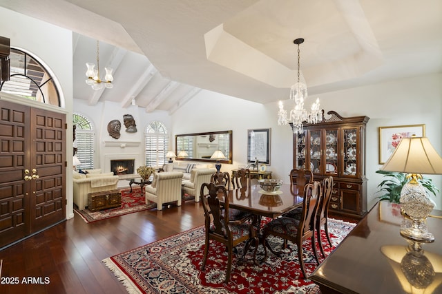 7955 E Chaparral Rd Unit 129, Scottsdale, AZ 85250 - dining space featuring a chandelier, hardwood / wood-style flooring, a lit fireplace, and vaulted ceiling