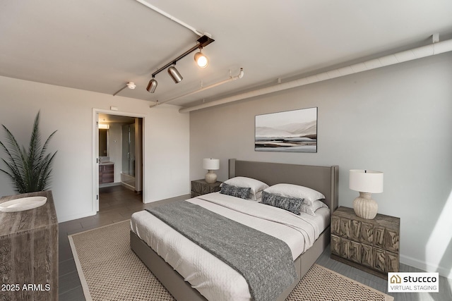 bedroom featuring baseboards and track lighting