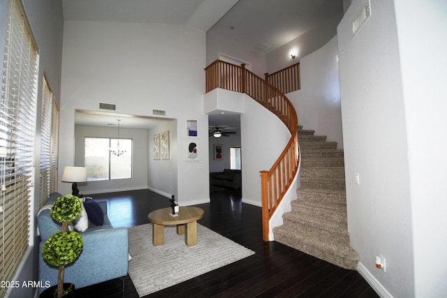 entrance foyer featuring an inviting chandelier, dark wood-type flooring, and a high ceiling