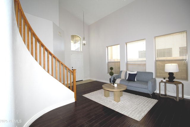 living room featuring dark wood-type flooring and high vaulted ceiling