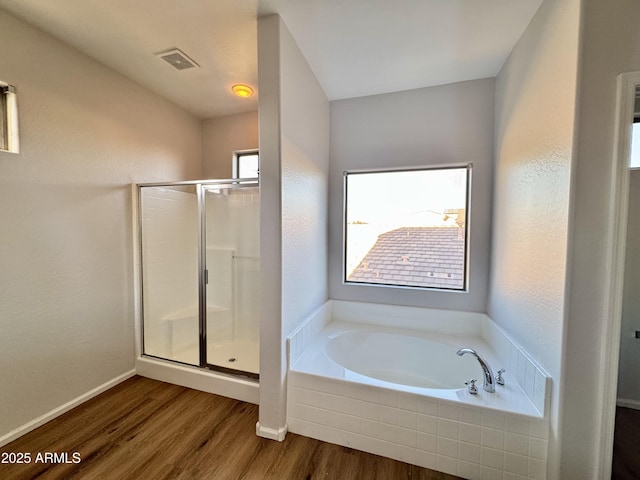 bathroom with independent shower and bath and hardwood / wood-style floors