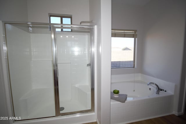 bathroom featuring hardwood / wood-style flooring, plus walk in shower, and a healthy amount of sunlight