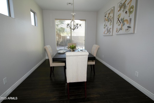 dining space with dark wood-type flooring and a chandelier