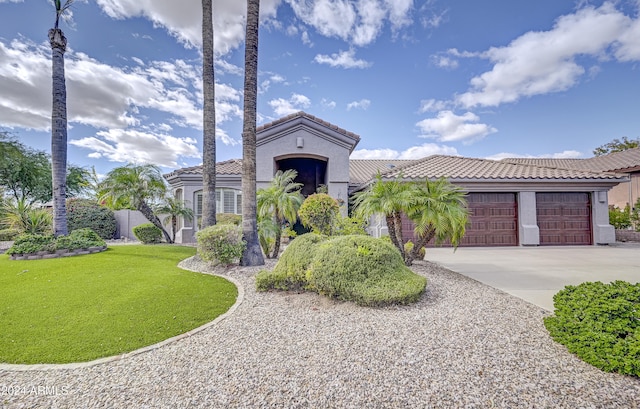 mediterranean / spanish house with a garage and a front lawn