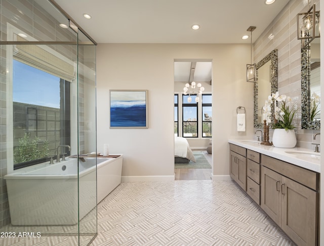 bathroom featuring a bathing tub, vanity, and a chandelier