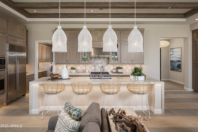 kitchen with independent washer and dryer, built in appliances, sink, and a breakfast bar area