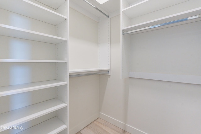 spacious closet with light hardwood / wood-style floors