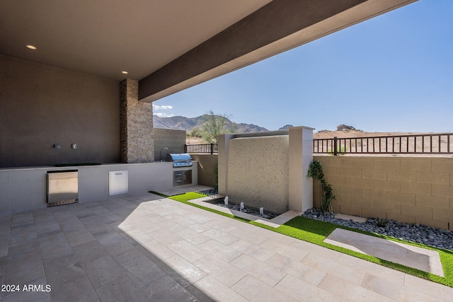 view of patio / terrace with exterior kitchen and a mountain view