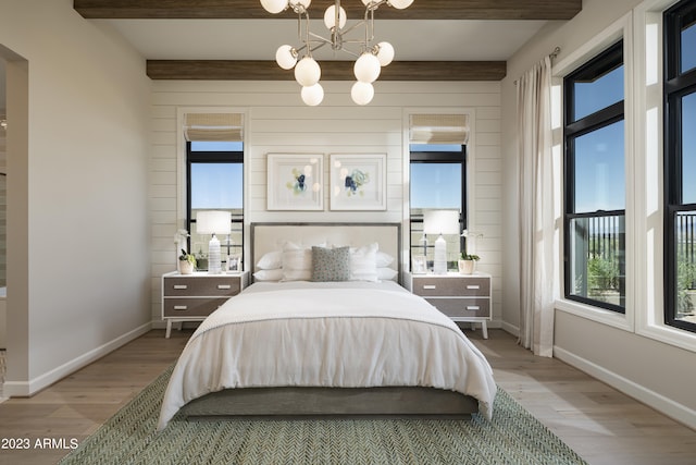 bedroom featuring hardwood / wood-style floors, a chandelier, and beamed ceiling