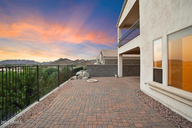 patio terrace at dusk featuring a mountain view