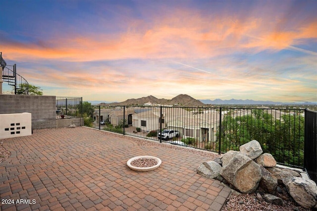 patio terrace at dusk with a mountain view and an outdoor fire pit