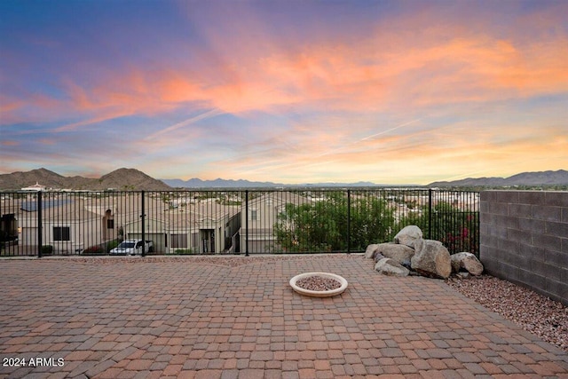 patio terrace at dusk featuring a mountain view and an outdoor fire pit