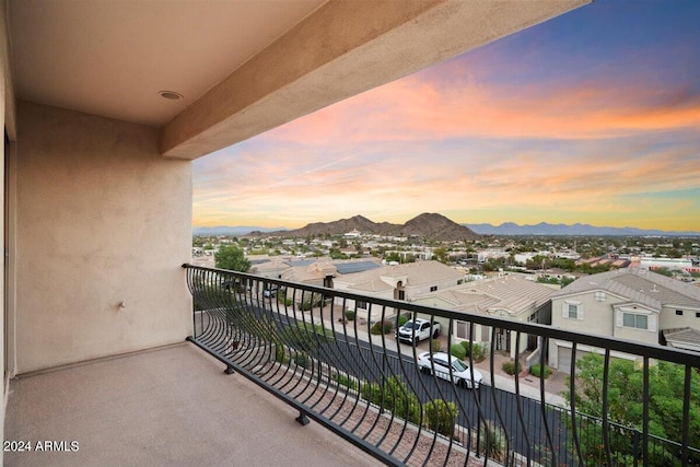 balcony at dusk featuring a mountain view