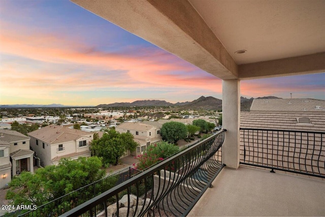 balcony at dusk featuring a mountain view