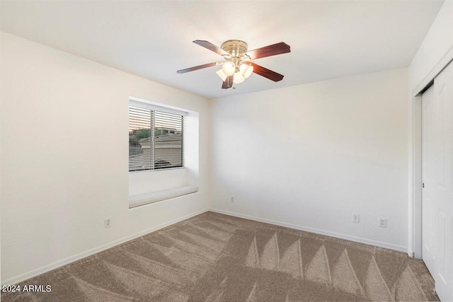 empty room with ceiling fan and carpet flooring