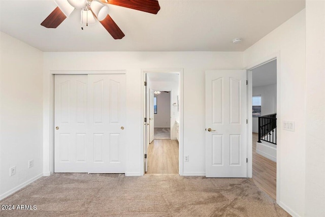 unfurnished bedroom with a closet, ceiling fan, and light colored carpet