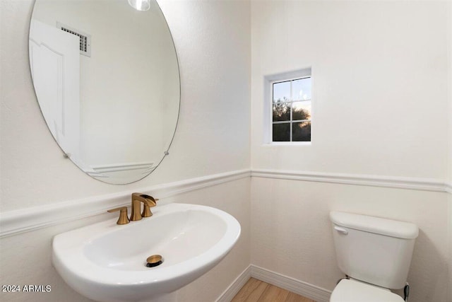 bathroom with sink, toilet, and hardwood / wood-style flooring