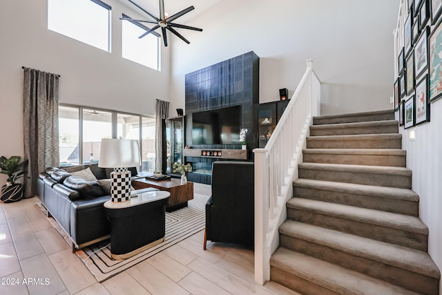 living room with ceiling fan and a towering ceiling