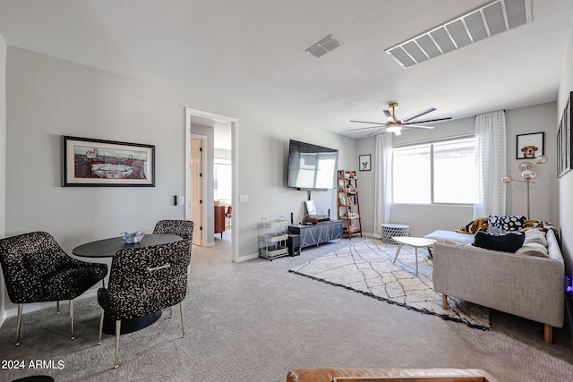 carpeted living room with ceiling fan